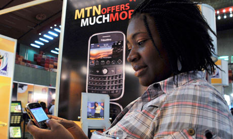 A delegate checks a BlackBerry at an exhibition during the West & Central Africa Com conference