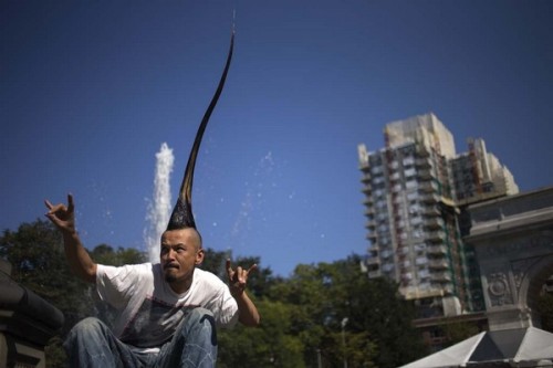 Japanese fashion designer Kazuhiro Watanabe, who holds the world record for the "Tallest Mohawk," poses for a photographer at a media event held by the Guinness World Records to launch their 2013 book edition in New York September 12, 2012. According to the Guinness World Records, Watanabe's do stands at 3 feet 8.6 inches. REUTERS/Adrees Latif (UNITED STATES - Tags: FASHION SOCIETY)