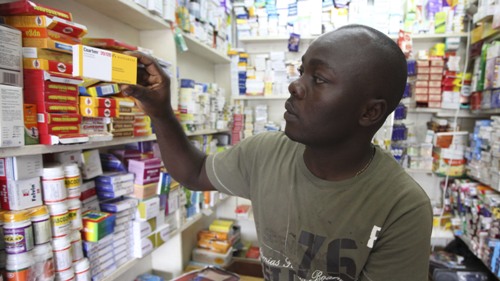 Ayo Bello grabs a box of malaria medication at a pharmacy in Lagos, Nigeria. A pilot project by the Global Fund has helped private pharmacies and clinics sell top quality malaria drugs at wholesale prices in Nigeria and seven other African countries.