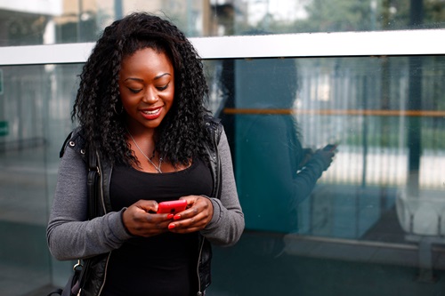 Young African woman reading a text message