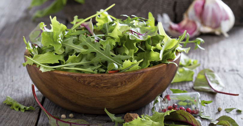 Green salad leaves in a wooden bowl